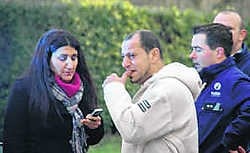 Met de tranen in de ogen kijkt Duraid Fouad (midden) naar de ravage die het vuur aanrichtte. dji