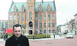 Een van de auteurs, Bart De Graeve voor het gemeentehuis. 'We hebben de geschiedenis van de buurt gereconstrueerd.' mye
