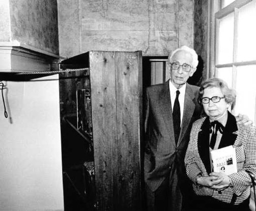 Miep Gies en haar man bij de boekenkast die naar het Achterhuis leidt waar de Franks ondergedoken leefden. epa