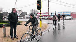 Jan Jonckheere kijkt toe hoe jonge fietsers veilig het kruispunt kunnen oversteken. mvn