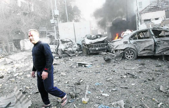 Een man wandelt tussen de brokstukken in de buurt van het Hamra-hotelinBagdad. Analisten zien in de aanslagen een poging om de Iraakse premier Nouri al-Maliki te verzwakken.epa