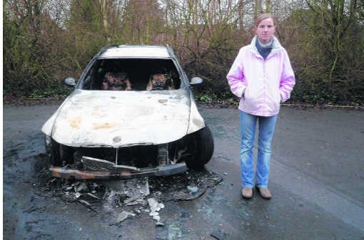 Sandra Meers bij de uitgebrande auto op de parking.N. Naets