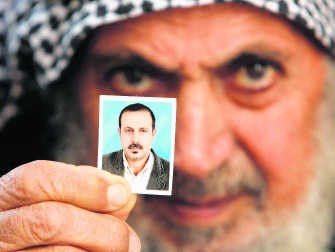 De vader van Mahmoud al-Mabhouh toont een foto van zijn vermoorde zoon. reuters