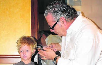 Kapper Luc brengt de pruik van Michiel in orde. Kizzy Van Horne