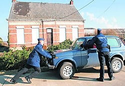 De politie duwt een wagen weg voor een van de veroordeelde hoeves. ena
