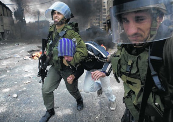 Israëlische oproerpolitie pakt een jonge Palestijn op tijdens rellen in het vluchtelingenkamp Shufat in Oost-Jeruzalem. Marco Longari/afp