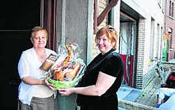 Chris Roes overhandigt een verrassingsontbijt aan de jarige Lucienne Arijs. Herman Laneau