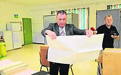 Burgemeester Willy De Waele van Lennik opent zijn stembrief maar geeft hem meteen terug aan de voorzitter van het stembureau. yds