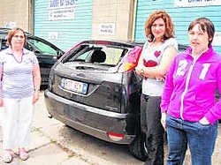 Linda Verstraeten, Ebtissem Chtioui en Isabel Verhaegen bij een auto die door de vandaal onder handen genomen werd.<br> Johan Van Bever