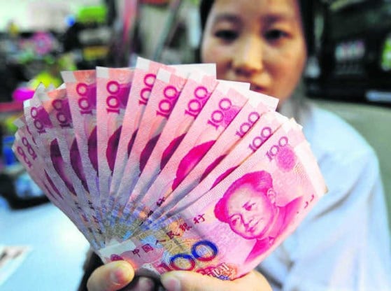 Een Chinese kruidenier toont zijn briefjes van 100 yuan. Worden Chinese exportproducten straks duurder?afp