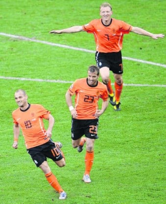 Wesley Sneijder viert zijn winnende treffer met Van der Vaart en Kuyt <br>in het zog. De keeper zag er niet goed uit bij die fase.Liu Jin/afp