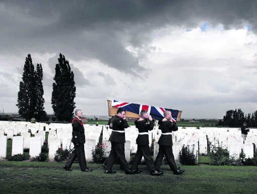 Militairen dragen de kist met stoffelijke resten van een Britse soldaat naar zijn laatste rustplaats op de militaire begraafplaats Tyne Cot in Zonnebeke.Joost van den Broek