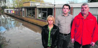 V.l.n.r. buurvrouw Veerle Compernolle, schepen Stijn Tant en directeur Rik Lambrecht voor de muur die het water uit de school houdt. Patrick Holderbeke