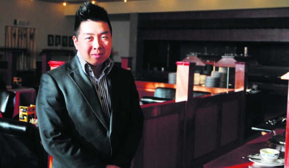 Uitbater Waiki Wang staat in zijn restaurant. Een deel van zijn personeelsleden heeft hij moeten ontslaan. phh