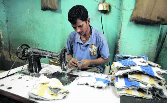 Microkredieten moeten het arme Indiërs mogelijk maken om een eigen bedrijfje op te richten, zoals dit kleine handschoenen-naaiatelier in een sloppenwijk in Mumbai.Adeel Halim/bloomberg