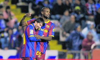 De kleine ster Lionel Messi viert in de armen van de lange Eric Abidal. afp