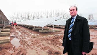 Roeland Vanhille van Eternit bij de zonnepanelen op het vroegere asbeststort. evr