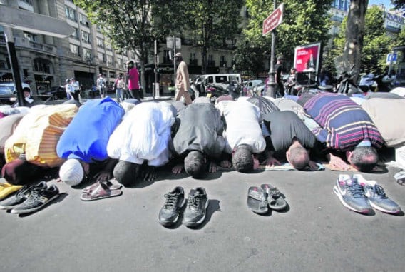 Biddende moslims in de Rue des Poissonniers in Parijs.Lucas Dolega/epa