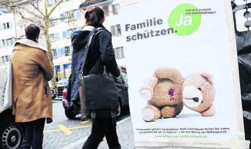 'Bescherm je familie - stem voor strengere wapenwetten', spoort deze affiche in Zürich aan. ap