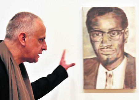 De hedendaagse Vlaamse meester Luc Tuymans in de Bozar naast zijn portret van Lumumba. afp