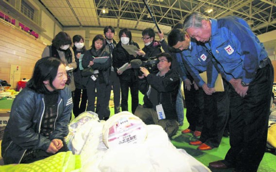 Norio Tsuzumi, de vicepresident van Tokyo Electric Power Co. (r.), verontschuldigt zich bij evacués in een opvangcentrum in Tamura. Koichi Nakamura/ap