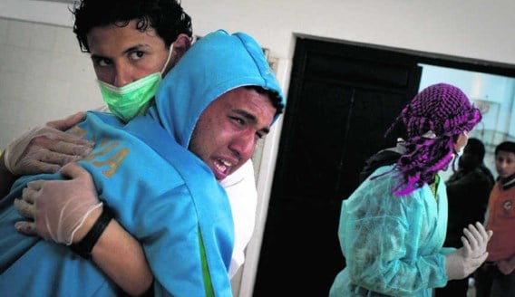 Een verpleger troost een Libische man die net zijn gedode broer geïdentificeerd heeft in een ziekenhuis in Benghazi. Anja Niedringhaus/ap