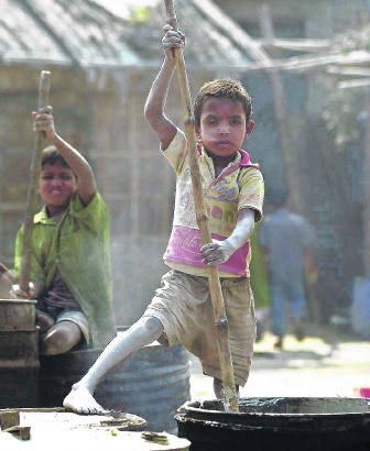 In een ballonnenfabriek in Kamrangir Char, in Bangladesh, moeten kinderen rubber mengen in open vaten.Pavel Rahman/ap