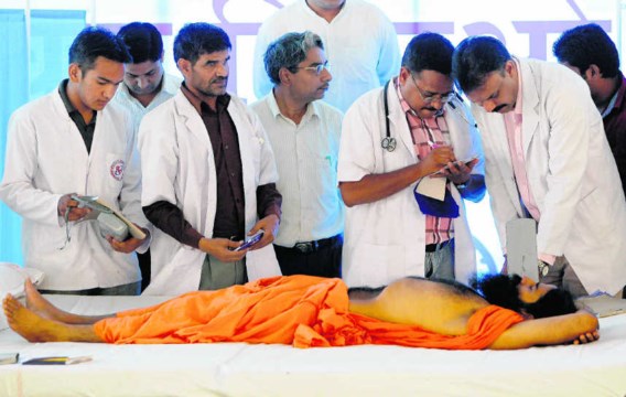 Een arts controleert de gezondheidstoestand van Baba Ramdev; zijn hongerstaking ging vrijdag haar zevende dag in. Gurinder Osan/ap