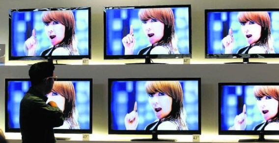 Een bezoeker van de IFA-beurs loopt langs een muur van 3 D-televisietoestellen. Wolfgang Kumm/epa