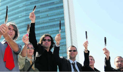 Een groep artiesten protesteert in Sarajevo tegen de politieke stilstand door met kraaienveren te zwaaien.ap