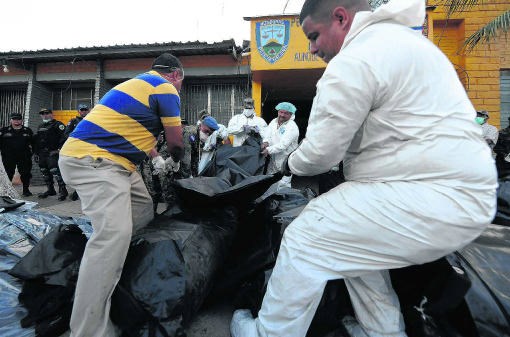 Hondurese forensische experts dragen de lijken weg van omgekomen gevangenen.afp