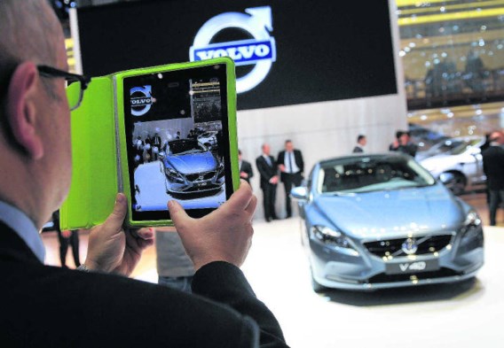 Een bezoeker van het autosalon maakt met zijn iPad een foto van de net onthulde Volvo V40.Fabrice Coffrini/afp