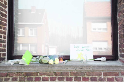 Voorbijgangers legden bloemen, kaarten en kaarsen bij het huis waar de baby werd gedood. belga
