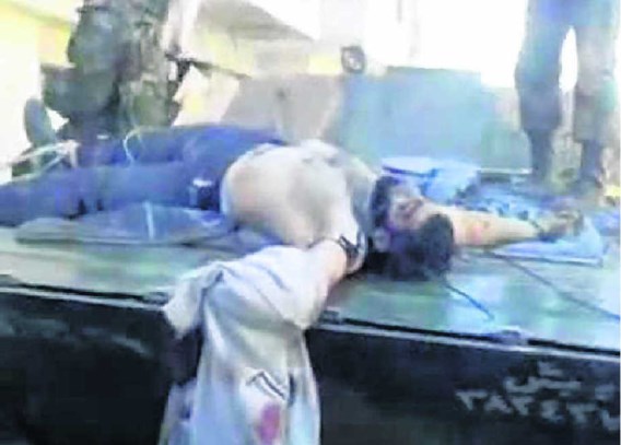 Een dode rebel wordt rondgereden op een regeringstank in Homs. Het beeld zou al dateren van 29 februari, maar werd pas recent op Youtube geplaatst. afp