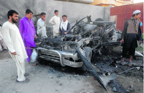 Inwoners van Jalalabad troepen samen rond het wrak van bomauto.Parwiz/reuters