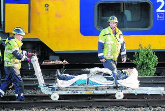 Een gewonde wordt weggevoerd na de treinbotsing. novum