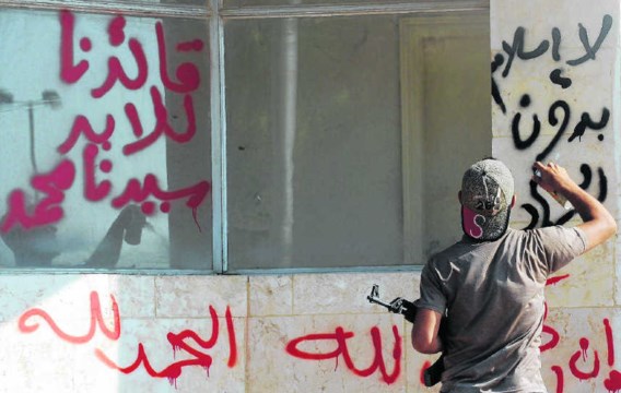‘Geen islam zonder jihad' spuit een lid van de jihadistische groep Shura Taliban Islam op de muur van de grenspost Bab al-Hawa, aan de Turks-Syrische grens.