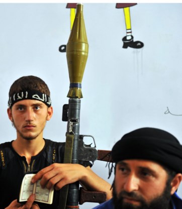 Een strijder van de Syrische oppositie zoekt steun in zijn koran.