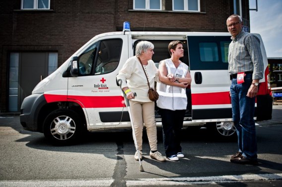 Onder begeleiding van het Rode Kruis wordt een dame teruggebracht naar haar woning.