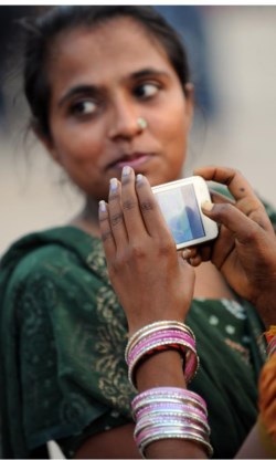 Een Indiase vrouw laat zich fotograferen met een smartphone.