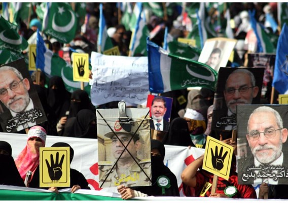 Pakistaanse medestanders van de Moslimbroeders in Egypte dragen in Karachi foto’s mee van Mohamed Badie (zie ook foto l.).