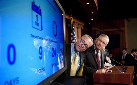 Harry Reid, de leider van de Democratische meerderheid in de Senaat (r.), en de Democratische senator Chuck Schumer kijken hoeveel tijd er nog rest tot de ‘shutdown’.