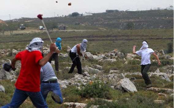 Palestijnse jongeren bekogelen Israëli’s in de buurt van de illegale nederzetting Ofra. De VN roepen België op om de kredietverstrekking een halt toe te roepen.
