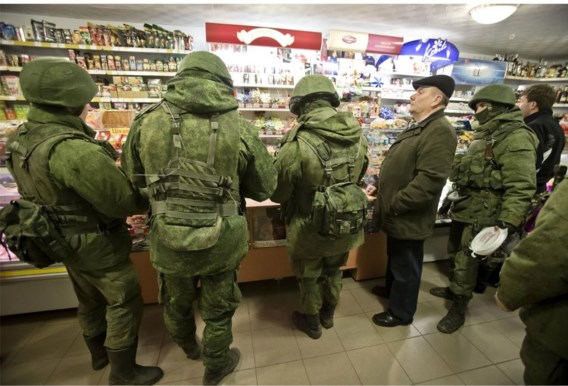 Half gemaskerde Russische soldaten doen inkopen op de Krim. Nog deze week zullen ze kunnen betalen met hun eigen roebels.