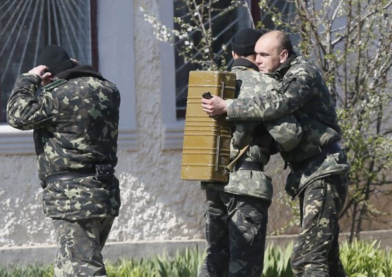 Oekraïense militairen nemen afscheid van elkaar nadat Russische soldaten hun basis in Perevalnoye hebben overgenomen.