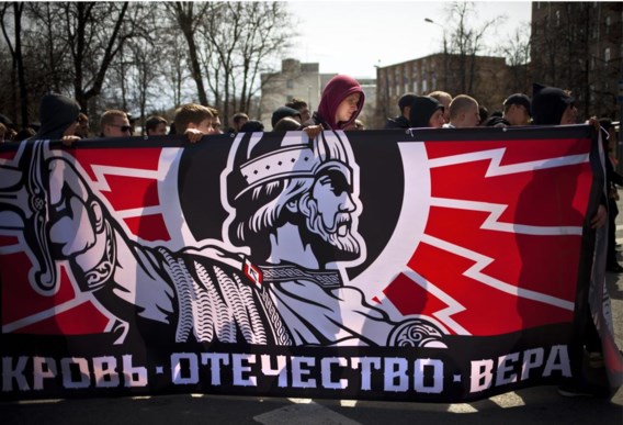 Russische nationalisten betogen in Moskou met een vlag van het oude Russische Rijk en daarop de boodschap ‘Bloed. Vaderland. Geloof’.