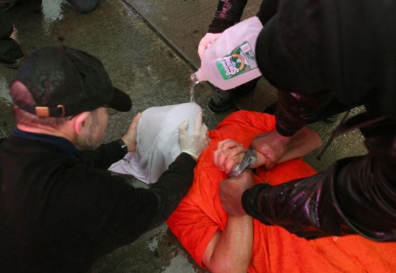 Betogers voeren een nep-waterboarding uit op Times Square.