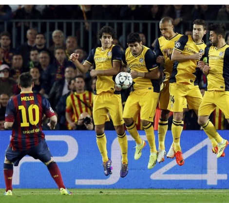 Een gele Madrileense muur veert op als Messi een vrijschop trapt. 