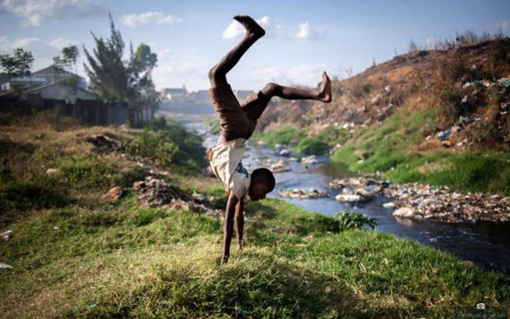 Een jongen voert een handenstand uit in een sloppenwijk van Nairobi, Kenia.