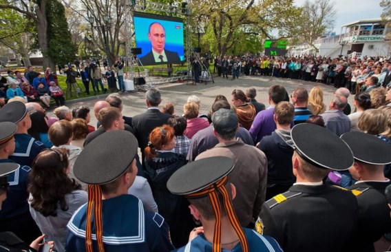 Inwoners van de Krim volgen op een groot tv-scherm in Sevastopol de jaarlijkse vraag-en-antwoord-marathon van president Vladimir Poetin.
